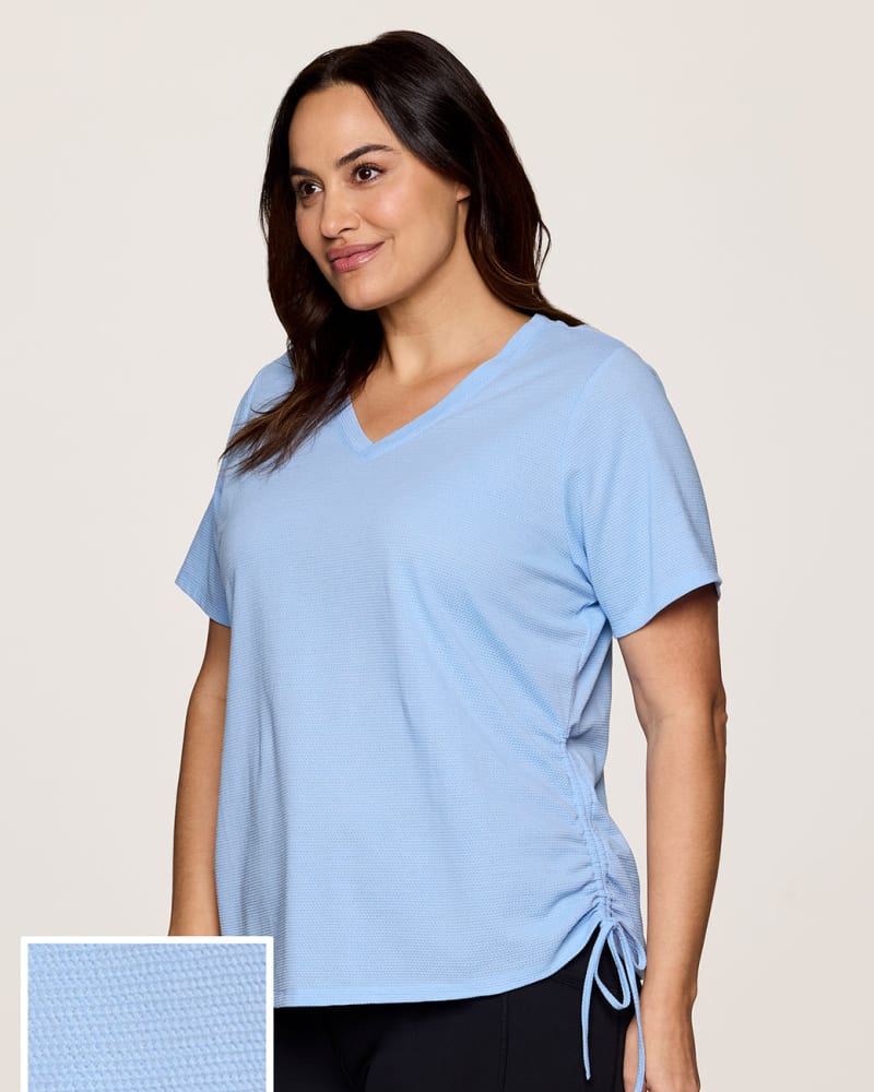 Side of a model wearing a size 1X Plus All In Ruched Tee in Light Blue by RBX Active. | dia_product_style_image_id:331598